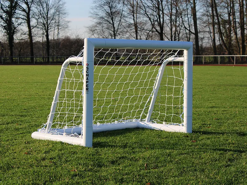 Kleines weißes Mini-Fußballtor mit weißem Netz auf Sportplatz mit Rasen