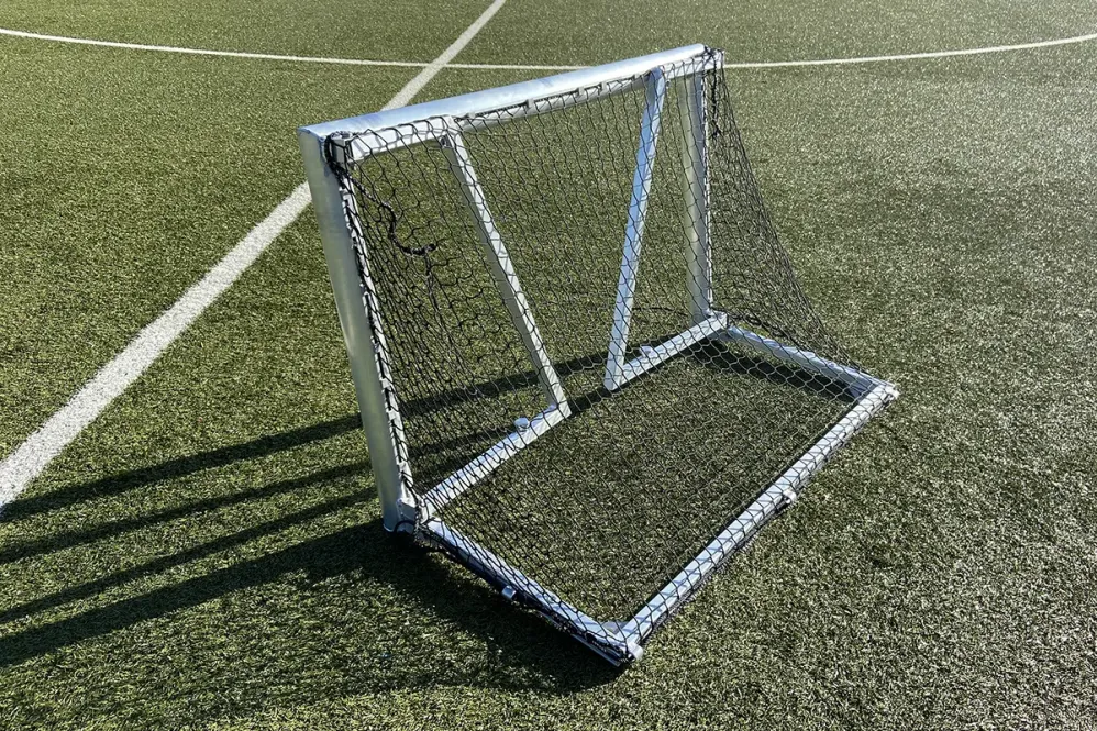 Klappbares Profi-Mini-Fußballtor mit Rundrahmen aus Aluminium, Abbildung geklappt auf Rasen liegend